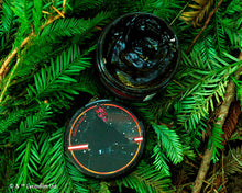 open jar of Darth Maul Firme Hold Pomade on green foliage